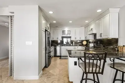 a kitchen with white cabinets and a black counter top at Blue Horizon - SUR67 in Solana Beach