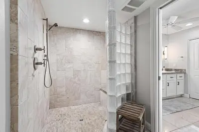 a bathroom with a shower with a bench in it at Blue Horizon - SUR67 in Solana Beach