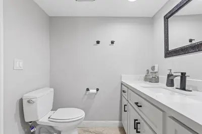 a white bathroom with a toilet and a sink at Blue Horizon - SUR67 in Solana Beach