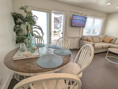 a dining room with a table and chairs and a couch at Steps from Ocean! Ocean and Bay Views! Rooftop Deck! Two-Car Garage! Renovated! in San Diego