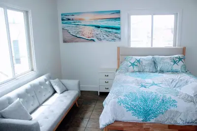 a bedroom with a bed and a couch at Steps from Ocean! Ocean and Bay Views! Rooftop Deck! Two-Car Garage! Renovated! in San Diego