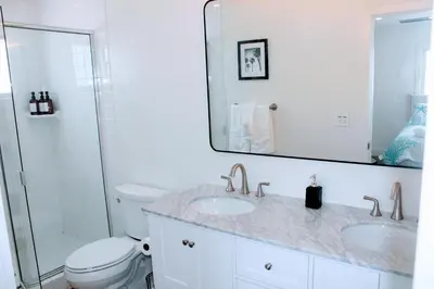 a bathroom with a sink and a toilet and a mirror at Steps from Ocean! Ocean and Bay Views! Rooftop Deck! Two-Car Garage! Renovated! in San Diego