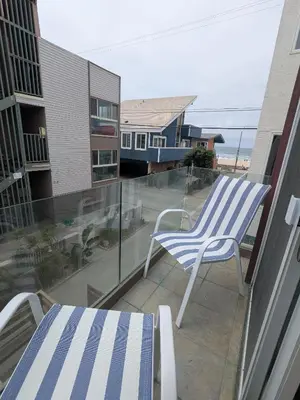 a blue and white chair sitting on a balcony at Steps from Ocean! Ocean and Bay Views! Rooftop Deck! Two-Car Garage! Renovated! in San Diego