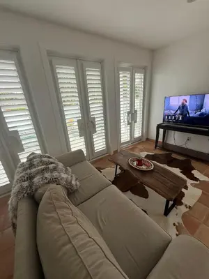 a living room with a couch and a flat screen tv at Private Encinitas Casita & Patio in Encinitas