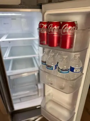 an open refrigerator with cocacola water and soda cans at BBQ Grill 5 mins to DT Canyon Views Parking in San Diego