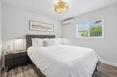 a white bedroom with a large bed and a window at Designer Home with Yard -Walk to Beach, Shops and More in Solana Beach