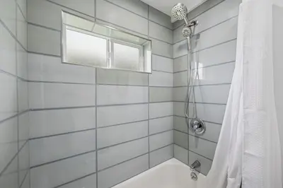 a white bathroom with a tub and a window at Designer Home with Yard -Walk to Beach, Shops and More in Solana Beach