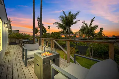 a patio with chairs and a table on a deck at Designer Home with Yard -Walk to Beach, Shops and More in Solana Beach