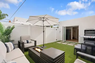a patio with a fire pit and an umbrella at La Jolla Beach Villa - Walk to Windansea Beach in San Diego
