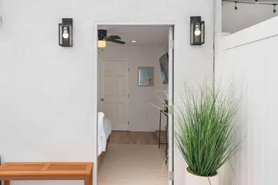 a hallway with a door leading into a room with a plant at La Jolla Beach Villa - Walk to Windansea Beach in San Diego