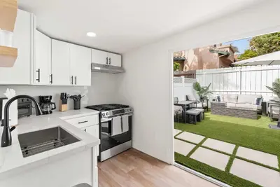 a kitchen with white cabinets and a patio with a yard at La Jolla Beach Villa - Walk to Windansea Beach in San Diego