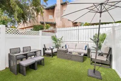 a patio with a table and an umbrella at La Jolla Beach Villa - Walk to Windansea Beach in San Diego