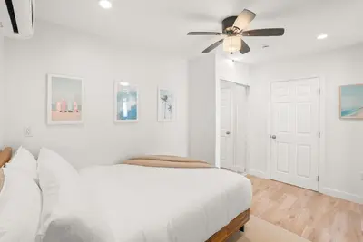a white bedroom with a bed and a ceiling fan at La Jolla Beach Villa - Walk to Windansea Beach in San Diego