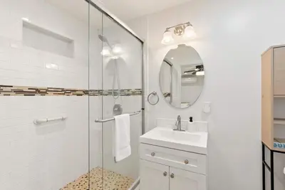 a bathroom with a shower and a sink and a mirror at La Jolla Beach Villa - Walk to Windansea Beach in San Diego