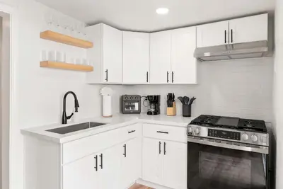 a kitchen with white cabinets and a stove top oven at La Jolla Beach Villa - Walk to Windansea Beach in San Diego