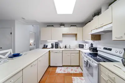a kitchen with white cabinets and white appliances at Cozy La Jolla Bungalow Near Beach & Village in San Diego