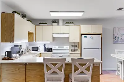 a kitchen with white cabinets and white appliances at Cozy La Jolla Bungalow Near Beach & Village in San Diego
