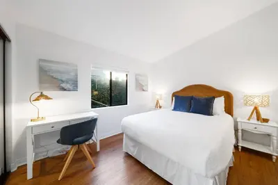 a white bedroom with a bed and a desk and a window at Cozy La Jolla Bungalow Near Beach & Village in San Diego