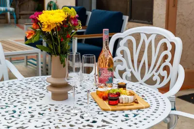 a table with a bottle of wine and a plate of food at Cozy La Jolla Bungalow Near Beach & Village in San Diego