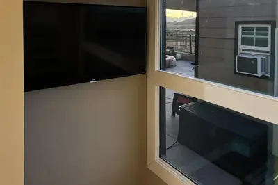 a room with two windows and a flat screen tv at Pool and Hot Tub Access Cozy Perris Tiny Home in Perris