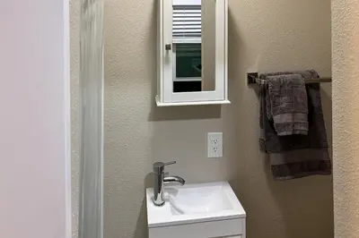 a bathroom with a sink and a mirror at Pool and Hot Tub Access Cozy Perris Tiny Home in Perris