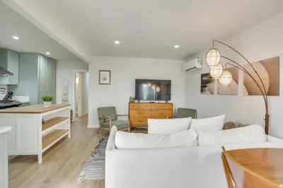 a living room with a white couch and a kitchen at Hip Walkable Neighborhood Condo in San Diego in San Diego