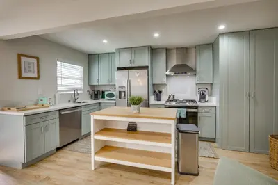 a kitchen with blue cabinets and a island in it at Hip Walkable Neighborhood Condo in San Diego in San Diego