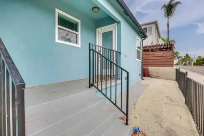 a blue house with a staircase leading to the front door at Hip Walkable Neighborhood Condo in San Diego in San Diego