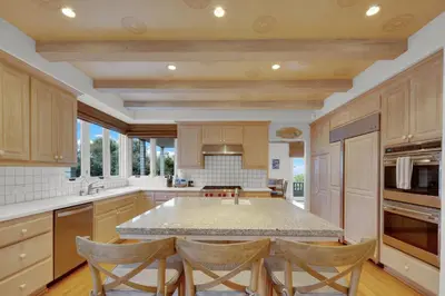 a kitchen with a large island with chairs in it at Fairway Retreat, Stylish Coastal Home Near Golf, Beaches & Carlsbad Fun in Encinitas
