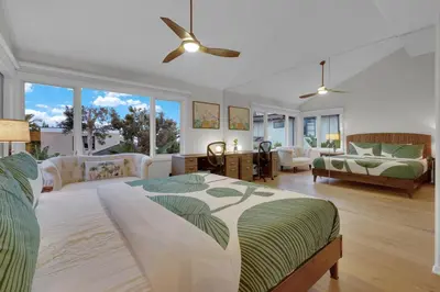 a bedroom with a large bed and a living room at Fairway Retreat, Stylish Coastal Home Near Golf, Beaches & Carlsbad Fun in Encinitas