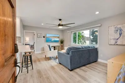 a living room with a couch and a table at Seabreeze 1BR, Walk to Sand, Pet Friendly, Parking, Fire Pit Access in Carlsbad