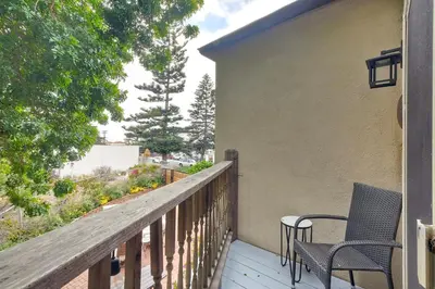 a balcony with two chairs and a table at Seabreeze 1BR, Walk to Sand, Pet Friendly, Parking, Fire Pit Access in Carlsbad