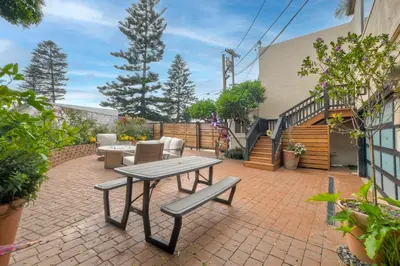 a patio with a table and chairs on a brick patio at Seabreeze 1BR, Walk to Sand, Pet Friendly, Parking, Fire Pit Access in Carlsbad