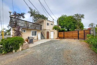 a house with a wooden fence and a driveway at Seabreeze 1BR, Walk to Sand, Pet Friendly, Parking, Fire Pit Access in Carlsbad