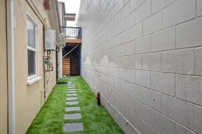 an alley between two buildings with a red fire hydrant at Luxury Beach Duplex, Sleeps 9, Dog-Friendly, AC, Fire Pit & Grill in Carlsbad