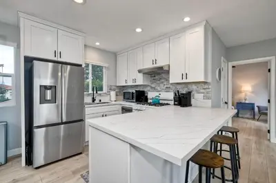 a kitchen with white cabinets and a white counter top at Luxury Beach Duplex, Sleeps 9, Dog-Friendly, AC, Fire Pit & Grill in Carlsbad