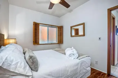 a bedroom with a white bed and a window at Exclusive Beachfront Duplex in Carlsbad Village Ocean Views, Sleeps 9 in Carlsbad