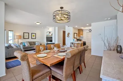 a dining room and living room with a table and chairs at Exclusive Beachfront Duplex in Carlsbad Village Ocean Views, Sleeps 9 in Carlsbad
