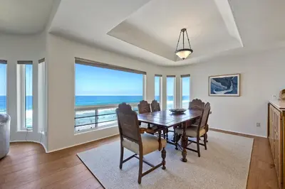 a dining room with a table and a view of the ocean at Exclusive Beachfront Duplex in Carlsbad Village Ocean Views, Sleeps 9 in Carlsbad