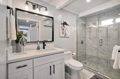 a white bathroom with a sink and a shower at Steps to Beach, 2BR Dog Friendly Home with Fire Pit in Carlsbad