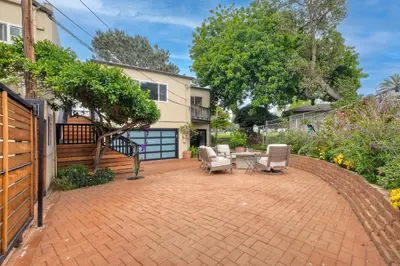 a patio with chairs and a table and a house at Steps to Beach, 2BR Dog Friendly Home with Fire Pit in Carlsbad