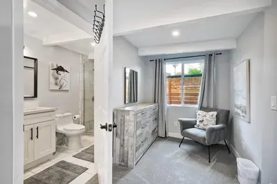 a bathroom with a sink toilet and a chair at Steps to Beach, 2BR Dog Friendly Home with Fire Pit in Carlsbad