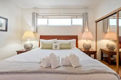 a bedroom with a large white bed with two lamps at Direct Beach Access, Views, Carlsbad 2BR Upper Unit in Carlsbad