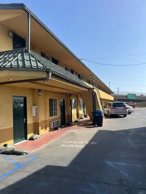 a building with cars parked in a parking lot at San Diego Inn in San Diego