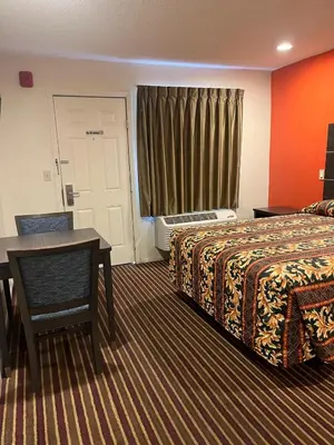 a hotel room with a bed and a table and a window at San Diego Inn in San Diego