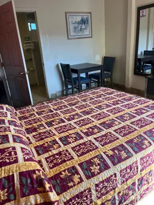 a bed in a room with a table and chairs at San Diego Inn in San Diego
