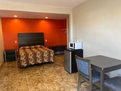 a room with a bed and a table and a microwave at San Diego Inn in San Diego