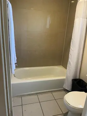 a bathroom with a white tub and a toilet at San Diego Inn in San Diego