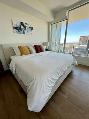 a large white bed in a room with a large window at The Daisy Bright 2BR Stay in Downtown San Diego in San Diego