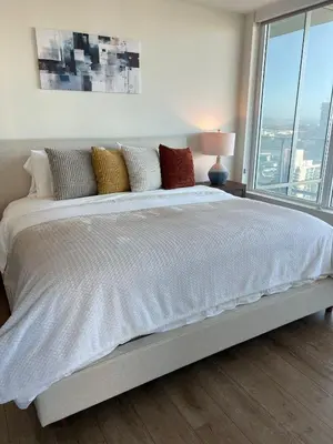 a large bed in a bedroom with a large window at The Daisy Bright 2BR Stay in Downtown San Diego in San Diego